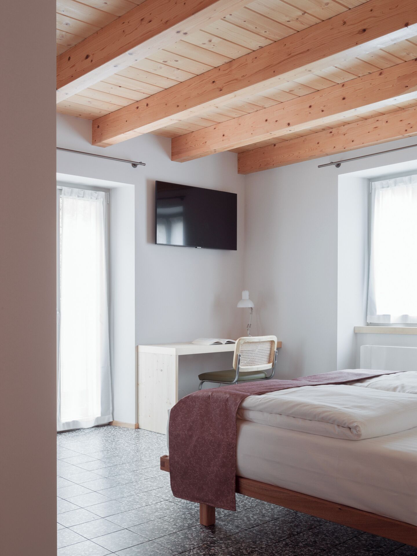Une chambre  à coucher avec un lit, un bureau et un téléviseur.