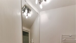 A bathroom with a white sink, a mirror, and a towel rack. - Beautiful, quiet apartment 5 minutes from Place Stan! (Nancy)