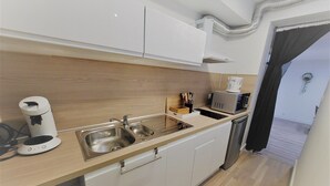 A modern kitchen with stainless steel appliances, a coffee maker, and a microwave. - Beautiful, quiet apartment 5 minutes from Place Stan! (Nancy)