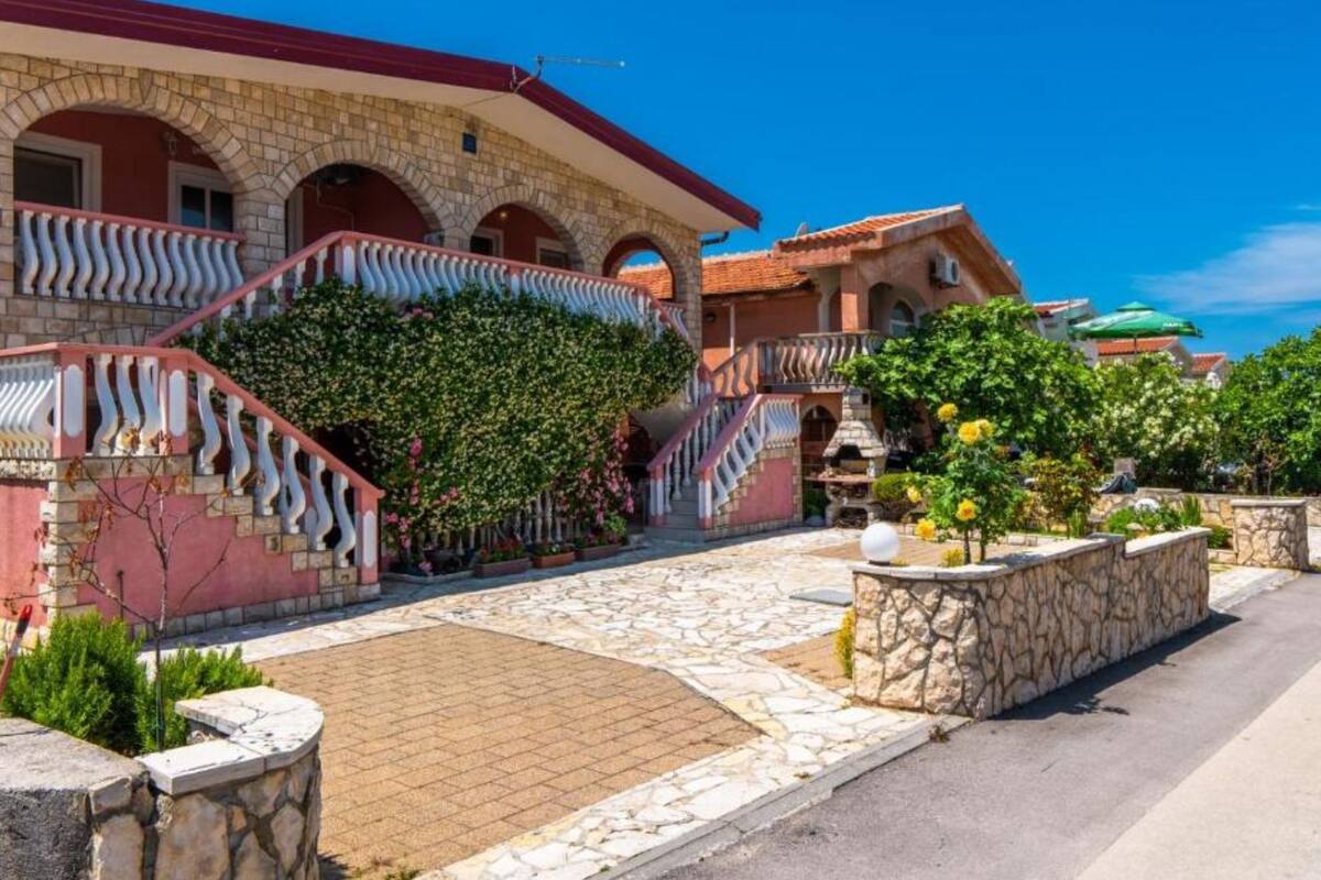 A traditional building with a stone facade, a curved roof, and a staircase with a decorative railing.