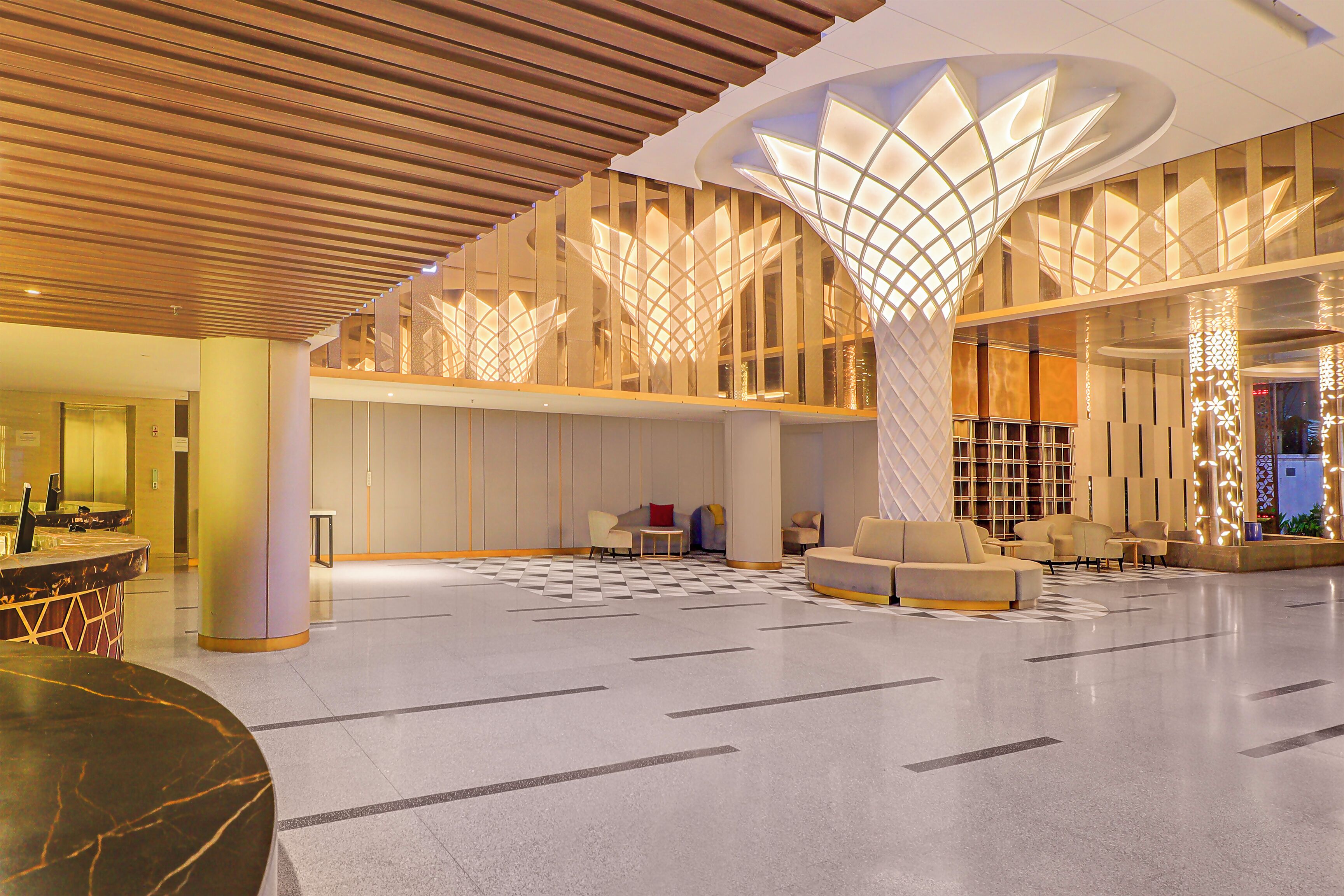 A spacious lobby with a high ceiling, modern seating areas, and a central column.