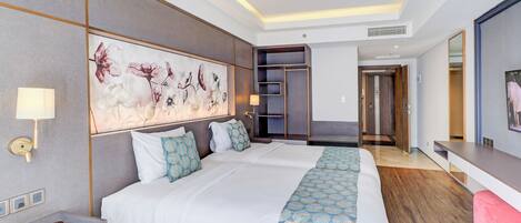 A hotel room with a large bed, bedside tables, a wall-mounted artwork, and a modern design.
