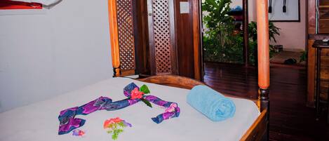 A room with a bed, a canopy, and a wooden door with a lattice design.