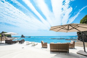 A beachside patio with wicker furniture and umbrellas, overlooking the ocean. - BEACH TERRACE KUSHIMOTO (Kushimoto)