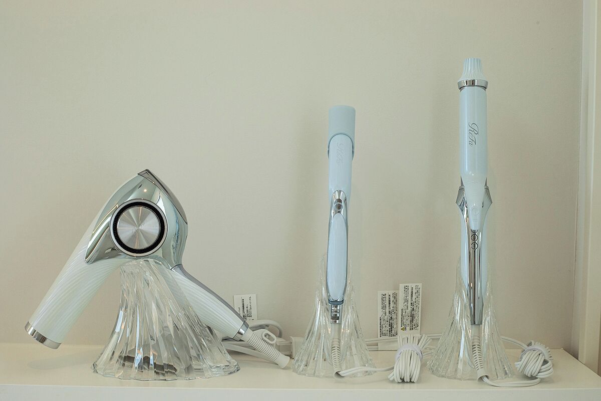 Three hair dryers on display with their cords and packaging.