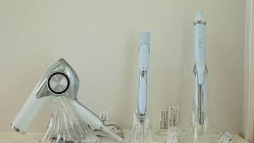 Three hair dryers on display with their cords and packaging.