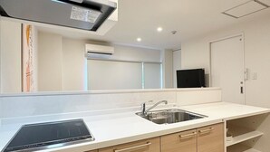 Een moderne keuken met een inbouwfornuis, een spoelbak en houten keukenkastjes.
