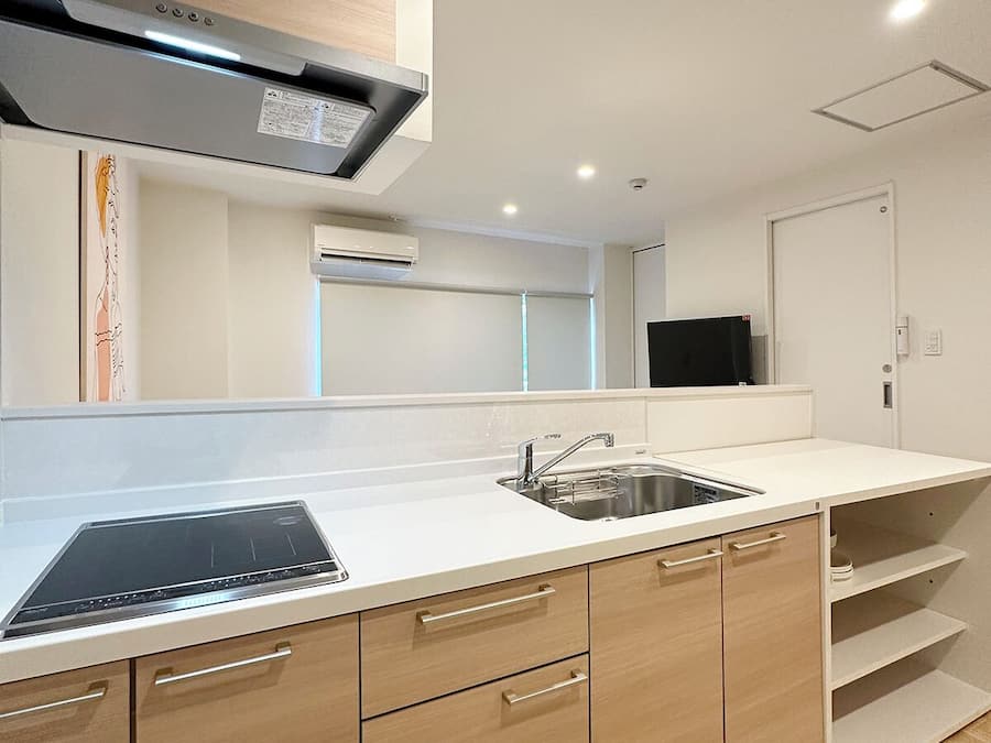 Una cocina moderna con estufa integrada, un lavaplatos y armarios de madera.