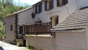 A two-story building with a balcony and a tiled roof.