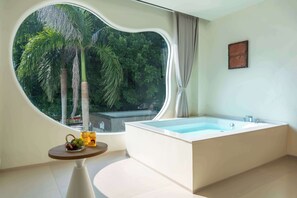 Relax in a serene bathroom with a spacious bathtub and lush views of greenery.