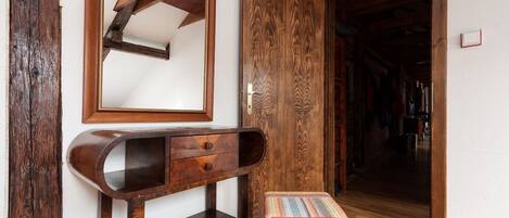 Una habitación con un escritorio de madera, un espejo y un tapete colorido.