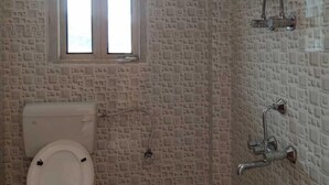 Une salle de bain comprenant des toilettes, une fenêtre, un lavabo et une douche.