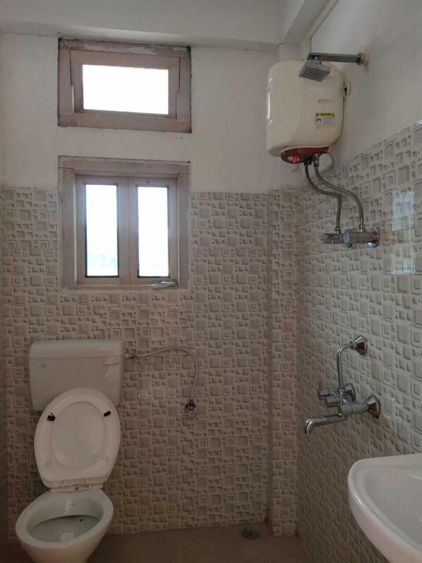 A bathroom with a toilet, a window, a sink, and a shower. - Hotel Vatika And Rooftop Restaurant (Lalkuwa)