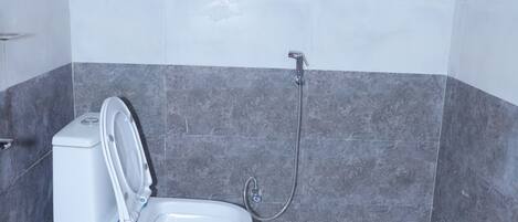 A bathroom with a toilet, a shower, and tiled walls.