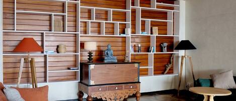 Una sala de estar acogedora con techo de madera, un sofá, una mesita de centro y una estantería.