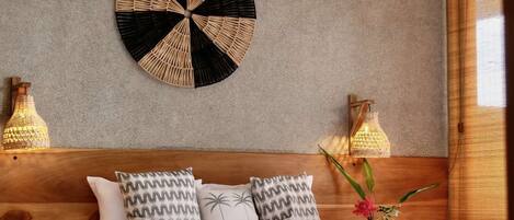 Une chambre à coucher avec une tête de lit en bois, un élément décoratif rond au mur et deux lampes de chevet.