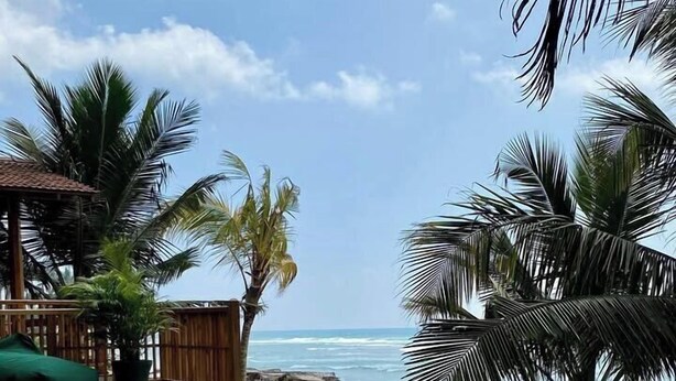 A pool area with a view of the ocean, surrounded by palm trees and a wooden deck. - Coast 67 Boutique Hotel (Ahangama)
