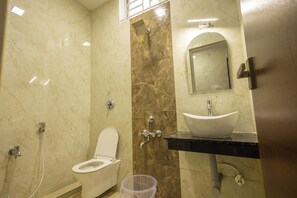 Une salle de bain avec des toilettes, un lavabo et une douche.