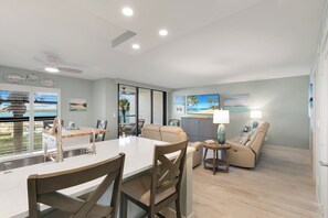 Una sala de estar moderna con comedor, un sofá y vistas al exterior.