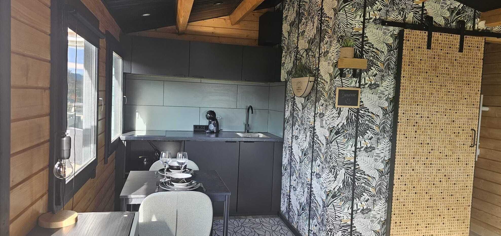 Een kleine keuken met een spoelbak, een eethoekje en een raam.