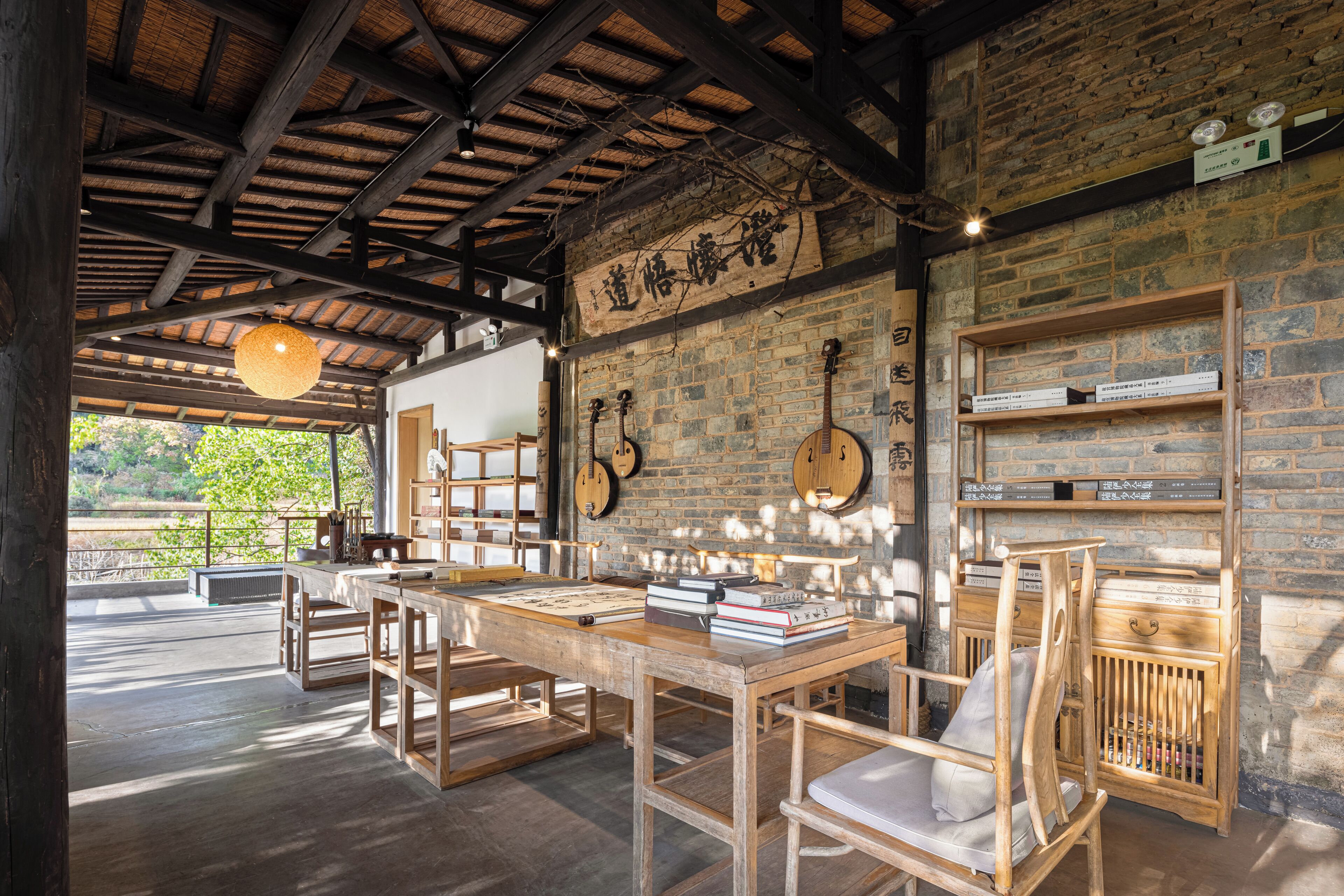 A rustic wooden interior with exposed brick walls, wooden furniture, and a thatched ceiling.