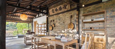 A rustic wooden interior with exposed brick walls, wooden furniture, and a thatched ceiling.
