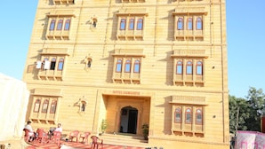 Um edifício com várias janelas e uma placa com a inscrição 'HOTEL SAMARTH'.