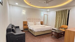 Quarto moderno com cama, sofá, escrivaninha e ventoinha de teto.