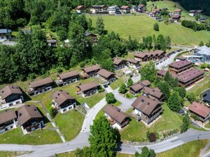 An aerial view of a residential area with multiple houses, roads, and greenery.