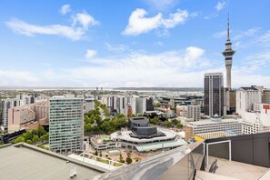 A cityscape with modern buildings, a prominent tower, and a waterfront view. - Pool, Gym & Modern 2BR Sky Tower View by Zodiak (Auckland)
