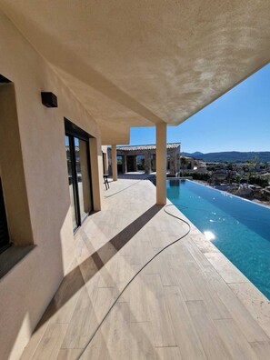 A poolside area with a clear view of the pool and distant landscape. - VILLA WITH OCEAN AND MOUNTAIN VIEWS (PALASCA)