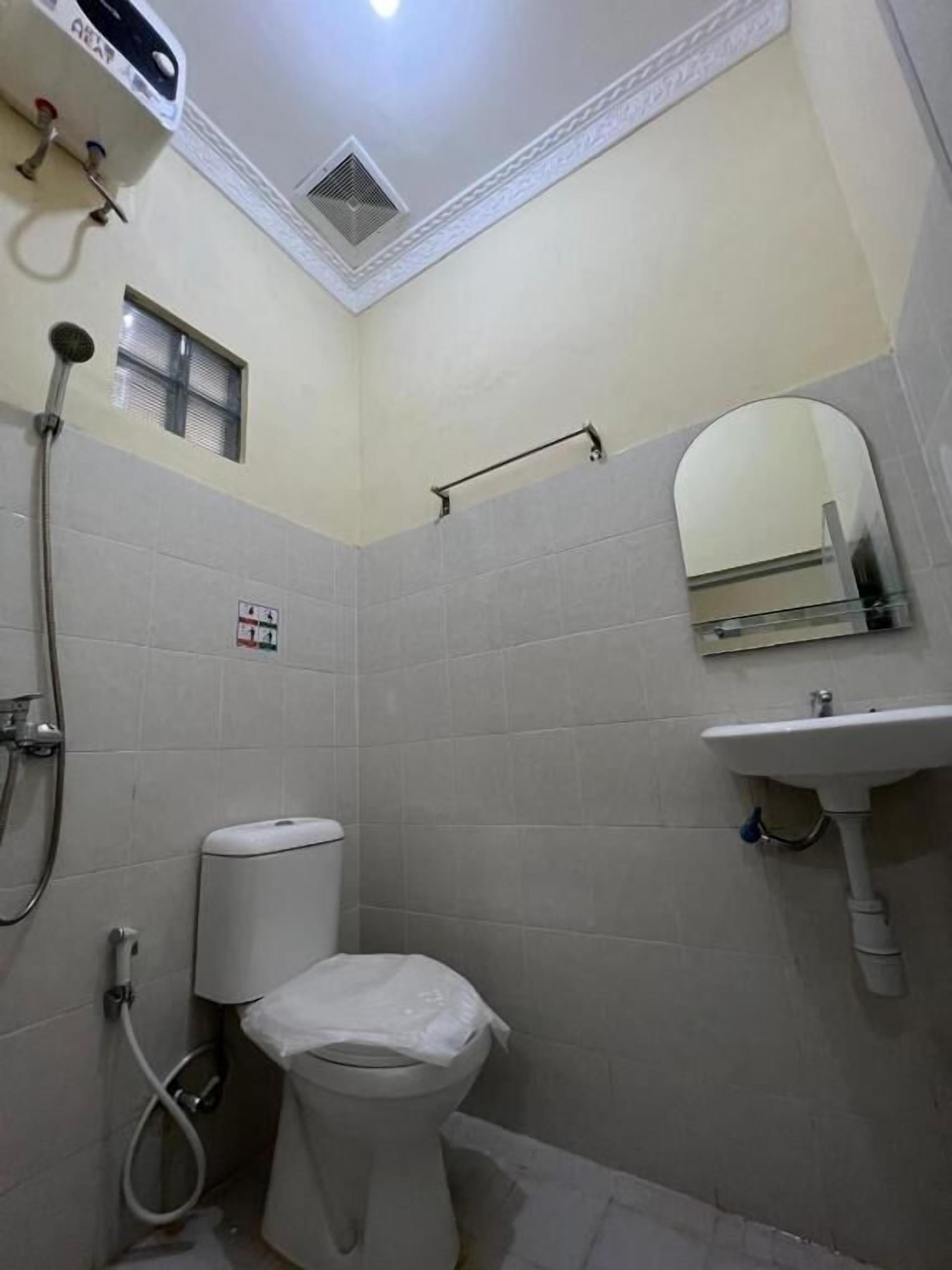 A small, compact bathroom with a toilet, shower, and sink.