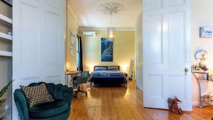 Une chambre à coucher avec un lit, un bureau, une chaise et un canapé.