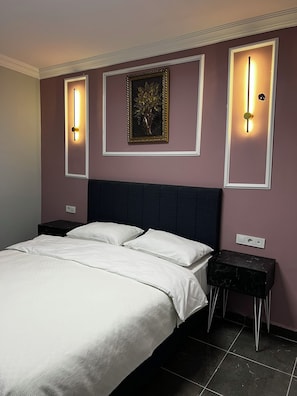 A bedroom with a bed, two nightstands, and wall-mounted lighting fixtures. - Varna Hotel (Kesan)