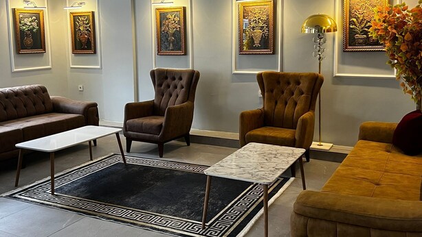 Una sala de estar moderna con un sofá, sillones, una mesa de centro y una alfombra.
