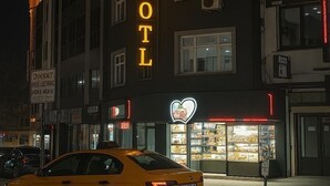 Un edificio con un letrero de neón que dice "VARN HOTEL" y un letrero de neón con forma de corazón debajo.