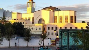 A modern building with a prominent tower and a dome, surrounded by a well-maintained plaza with a glass structure. - apartment ibiria (Tangier)