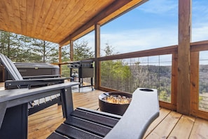 Terraza exterior con una parrilla, un pozo de fuego y vistas del paisaje circundante.
