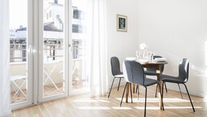A dining area with a table set for four, a sliding glass door leading to an outdoor balcony, and a framed picture on the wall.
