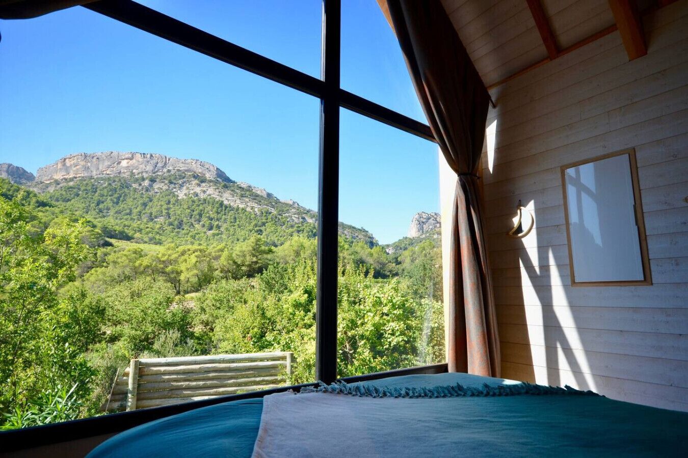 A room with a large window overlooking a mountainous landscape.