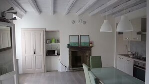 Una cocina moderna con armarios blancos, una mesa de comedor y lámparas colgantes.