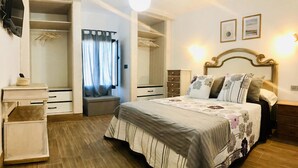 Un dormitorio con cama, mesita de noche, armario y espejo.