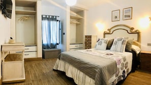 A bedroom with a bed, a bedside table, a nightstand, a wardrobe, and a mirror. - Apartment Alegria in the Stunning Village of Mozaga, Lanzarote (Teguise)
