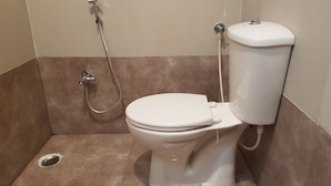 Un baño con inodoro, ducha y desagüe.