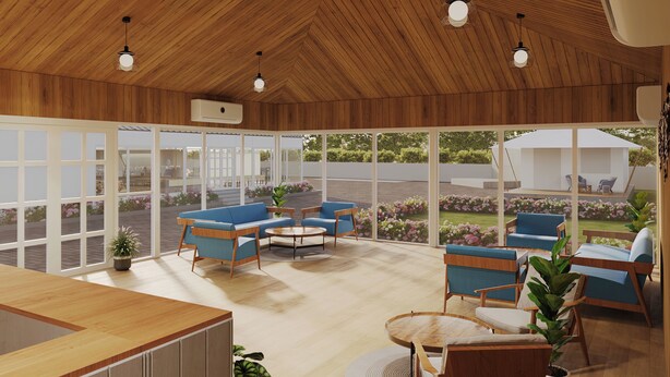 Amplio espacio interior con techo de madera y ventanas grandes, amoblado con sofás azules y una mesa redonda.