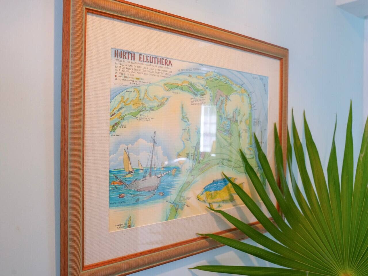 Eine gerahmte Karte mit dem Titel „North Eleuthera“ mit Illustrationen von Segelboot und Fisch.