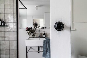 A bathroom with a white sink, a mirror, and a towel hanging on the wall. - Kent House (Ballarat Central)