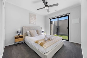 A bedroom with a bed, bedside table, lamp, and a ceiling fan. - Ballarat Bliss at Kevlar (Canadian)