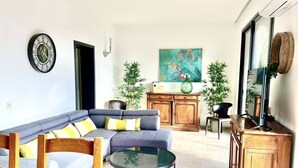 A living room with a sectional sofa, a round coffee table, and a wooden cabinet. - Le Belvedere-Charme de la Provence (Montauroux)