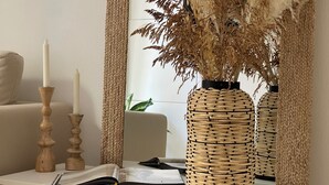 A room with a white sofa, a mirror reflecting a window with a plant, and a table with a book and candles. - Luxury 2 bedroom sleeps 6, balcony, city center, ideal to visit Cinque Terre (La Spezia)